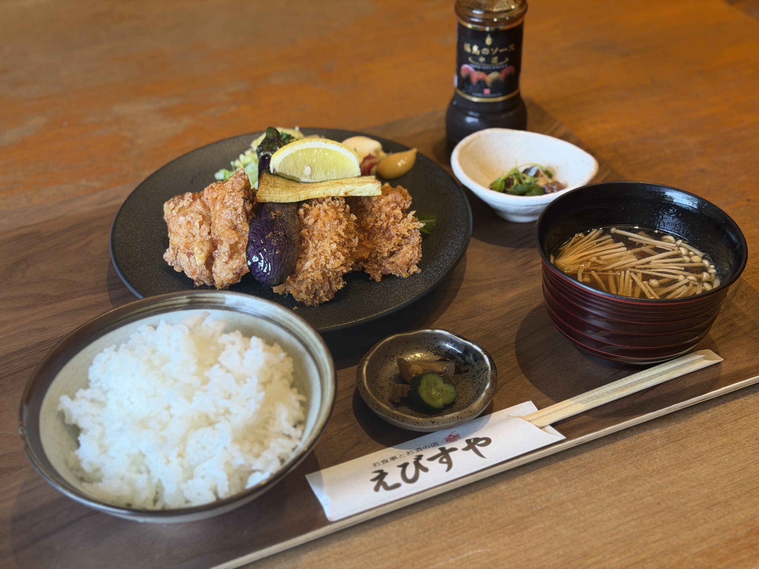 大きな唐揚げとヒレカツが盛られたえびすやの日替り定食。ご飯と小鉢、汁物付き